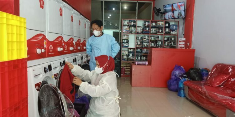 Dua karyawan Melati Laundry, Surahman dan Yuli saat bertugas, Rabu (28/7/2021)