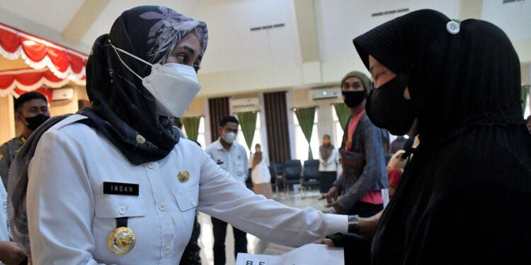 Bupati Luwu Utara, Indah Putri Indriani menyerahkan kunci huntap kepada penyintas banjir bandang. --Foto Protkopim Lutra--