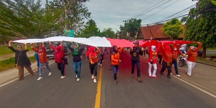 Warga mengarak bendera merah putih raksasa menuju puncak bukit Paleteang, Kabupaten Pinrang, Selasa (16/8/2022).