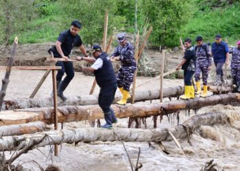 Pj Gubernur Sulsel, Bahtiar Baharuddin harus meniti jembatan bambu di atas sungai dengan arus deras untuk tiba di lokasi bencana, Kamis, (9/5/2024). (Foto: Humas Pemprov Sulsel)