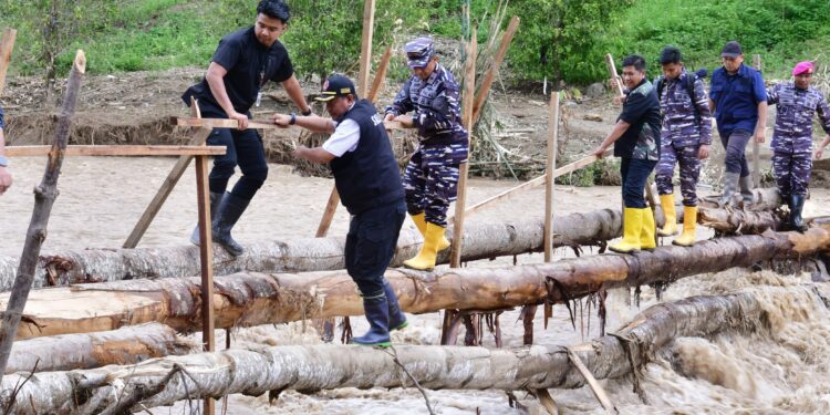 Pj Gubernur Sulsel, Bahtiar Baharuddin harus meniti jembatan bambu di atas sungai dengan arus deras untuk tiba di lokasi bencana, Kamis, (9/5/2024). (Foto: Humas Pemprov Sulsel)