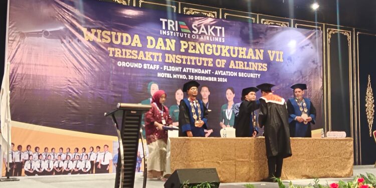 Salah satu wisudawan dikukuhkan oleh Direktur Triesakti Institute of Airlines, Sugeng Rianto dalam momen wisuda yang berlangsung kemarin, Senin (30/12/2024)