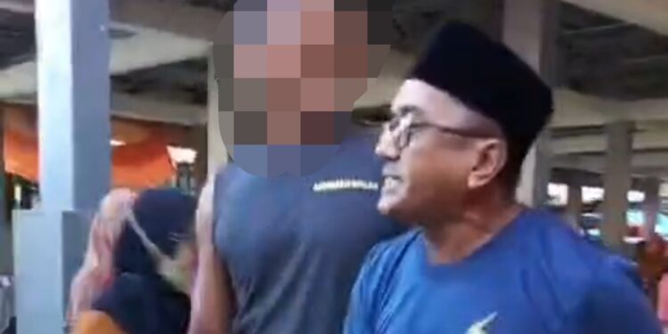 Pria yang diduga preman Pasar Pekkabata (blur) cekcok dengan Penjual Ikan, Sabarudin Wahab. Foto: Ist.