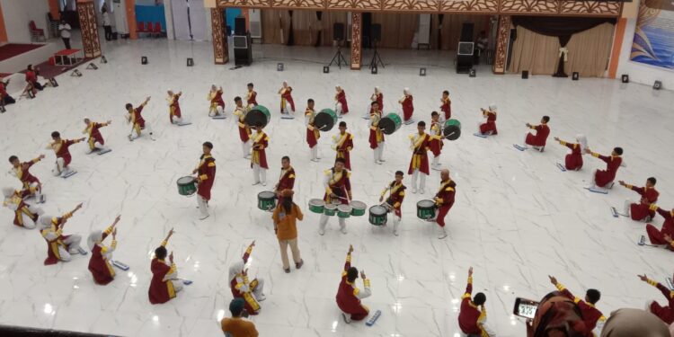 Penampilan energik dan penuh percaya diri ditunjukkan oleh Tim Swara Gema Ujung Moncong Drumband SMAN 4 Jeneponto pada ajang Phinisi Marching Competition (PMC) VII yang digelar di Auditorium Amanagappa UNM, Jumat (23/10/2026)